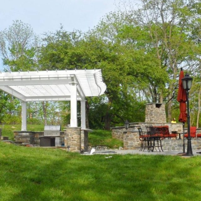 Outdoor pergola kitchen with seating area