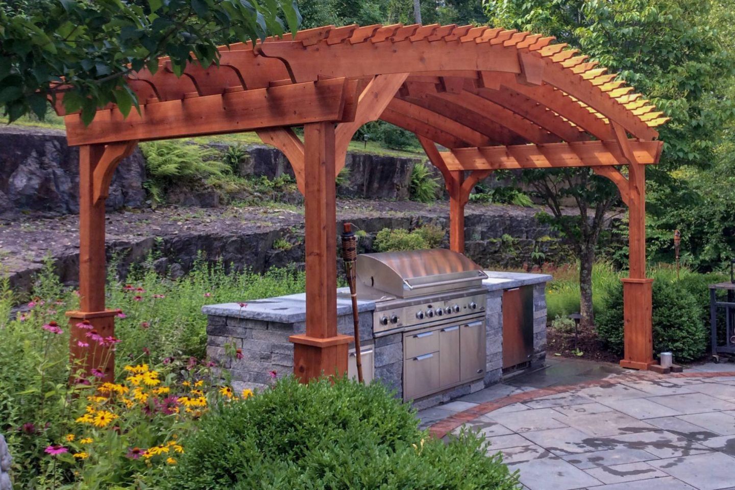 Wooden BBQ pergola with grill and landscaping